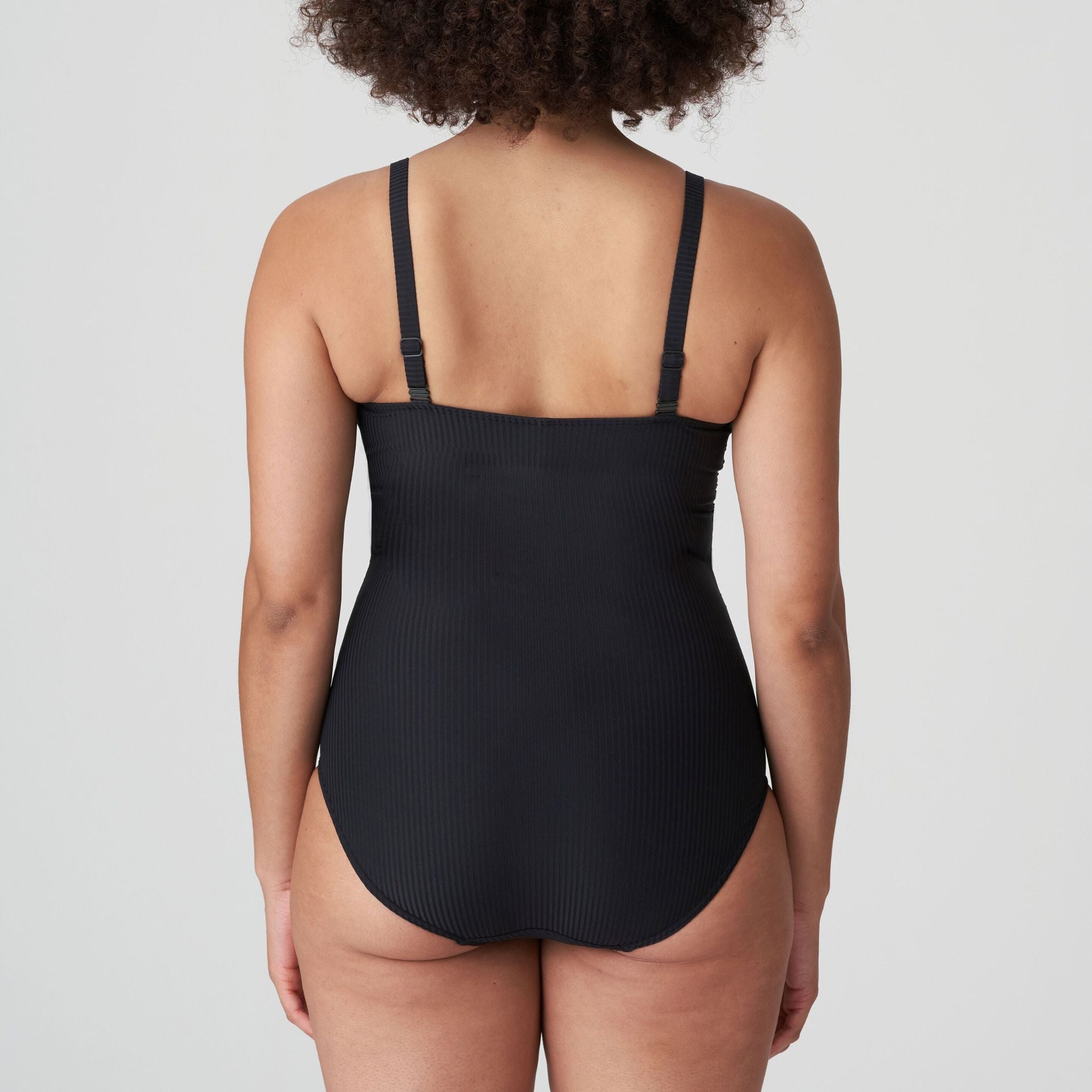 The seventies-style swimsuit has been given a trendy makeover with soft, textured fabric and a belt at the waist. The elegant shoulder straps complete the look!